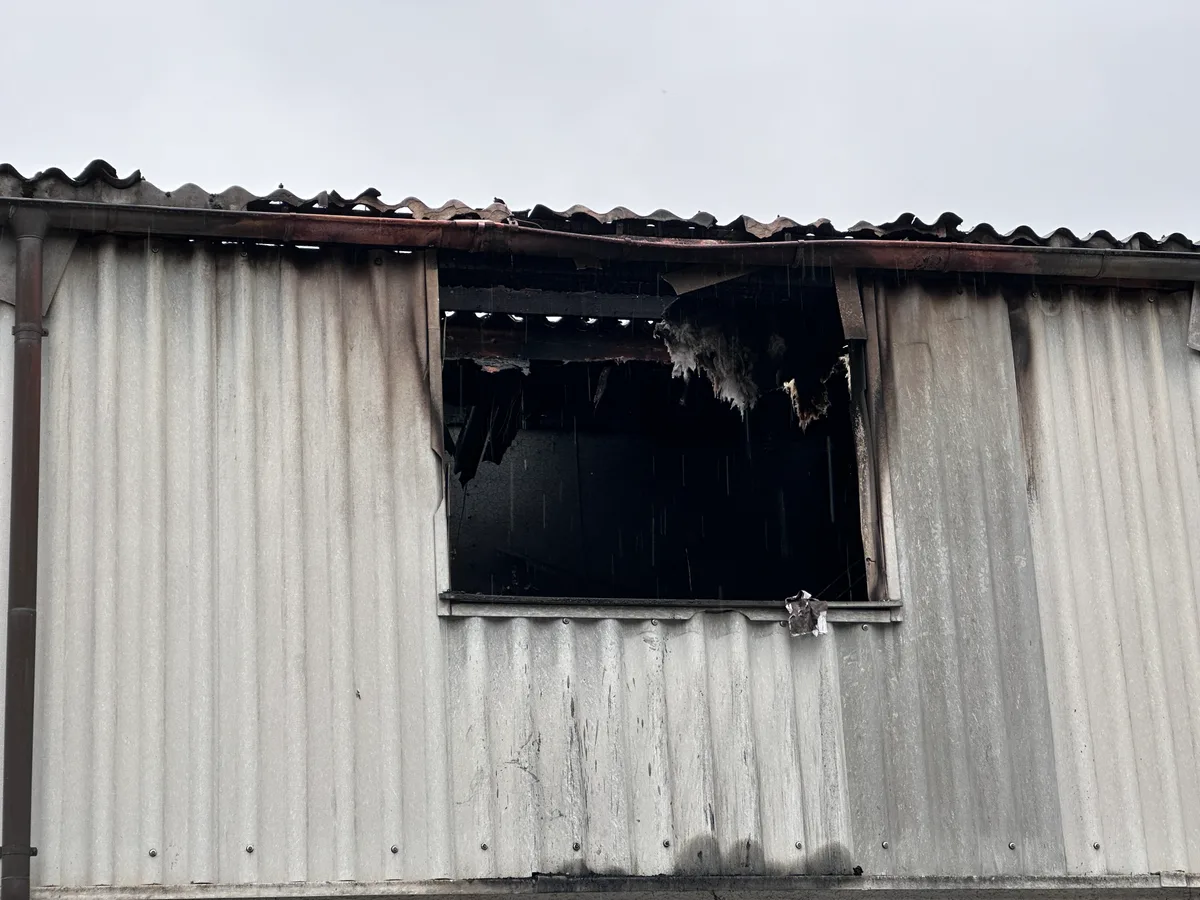 Blick von aussen auf eine Fassade mit einem von einem Brand zerstörten Fenster. 